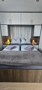 a bedroom with two beds and two night stands at Mobilheim Marine Glück im Yachthafen Peenemünde in Peenemünde