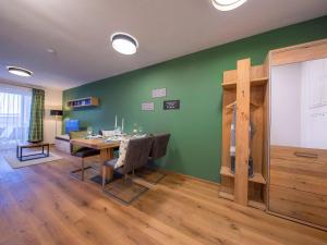 ein Esszimmer mit einem Tisch und einer grünen Wand in der Unterkunft Apartment in the heart of Neukirchen in Neukirchen am Großvenediger