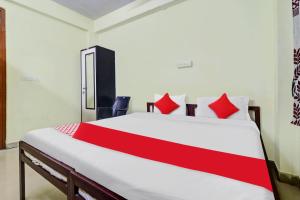 1 dormitorio con 1 cama grande con almohadas rojas en OYO Ruby Grand Inn Nallagandla, en Lingampalli