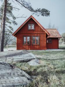 uma pequena casa vermelha no meio de um campo em Ytterön skärgårdshotell em Torhamn