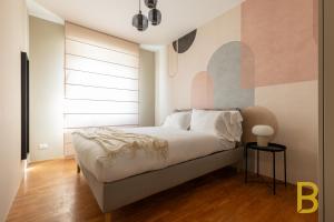 - une chambre avec un lit et un mur coloré dans l'établissement BePlace Apartments in Fiera, à Milan