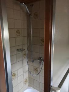 a shower with a hose in a bathroom at Haus Imgard in Lenzkirch