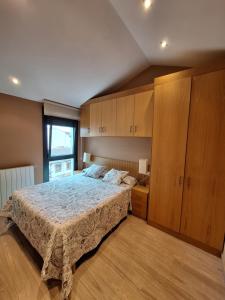 a bedroom with a large bed and wooden cabinets at Apartamento Enol in Cangas de Onís