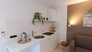 a white kitchen with a sink and a counter at Nido del relax in Murta Maria
