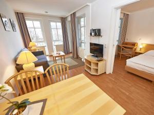ein Wohnzimmer mit einem Bett und ein Wohnzimmer mit einem TV in der Unterkunft Seepark Sellin - Apt. 635 in Ostseebad Sellin