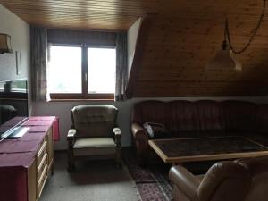a living room with a couch and a chair at Haus Imgard in Lenzkirch