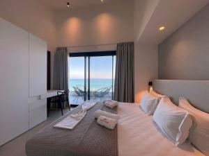 a bedroom with a large bed with a view of the ocean at Villa Adele in Polychrono