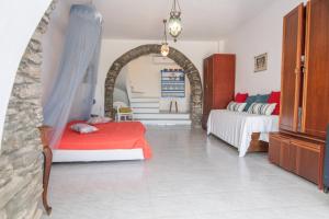 a bedroom with two beds and an archway at Tinos Sunset Villa in Kékhros