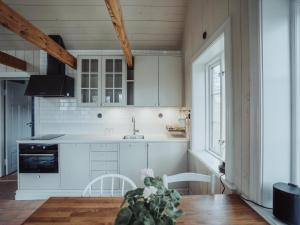 a kitchen with white cabinets and a table with a plant at Ytterön skärgårdshotell in Torhamn +43 photos