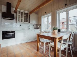 TorhamnにあるYtterön skärgårdshotellのキッチン(木製テーブル、白いキャビネット付)