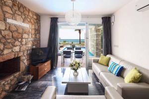 a living room with a couch and a fireplace at Villa Sapphire Paphos in Paphos City