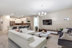 a living room with white furniture and a kitchen at 1509 MC - Exquisite 8BR Villa with Pool Games in Davenport