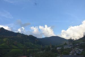 a view of a mountain range with clouds in the sky at Blue Bed Hostel in Nanu Oya