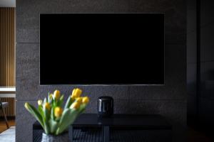 a vase of yellow flowers on a table with a tv at EASY RENT Apartments - Amber 10, Basen & SPA, Centrum Free Parking 24h Check-in in Lublin