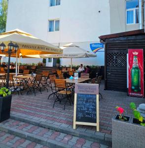 a patio with tables and chairs and a bottle of wine at CASABLANCA in Craiova