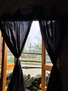 a window with black curtains looking out at a train at La Beauté Sa Pa in Sa Pa
