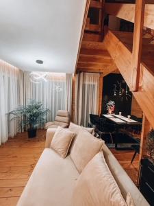 a living room with a white couch and a piano at Parkowy Kudowa in Kudowa-Zdrój