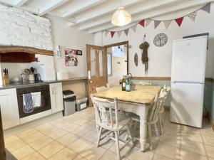 a kitchen with a table and a white refrigerator at 10 Mill Road in Padstow