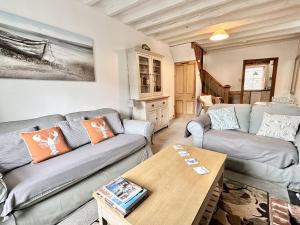 a living room with two couches and a table at 10 Mill Road in Padstow