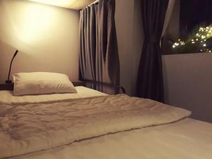 een wit bed in een kamer met een raam bij Adora for Expat in Can Tho