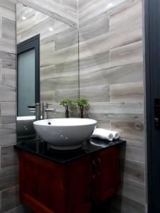 een badkamer met een wastafel en een spiegel bij Adora for Expat in Can Tho