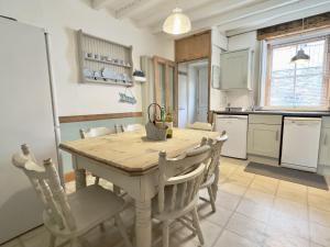 a kitchen with a wooden table and chairs at 10 Mill Road in Padstow
