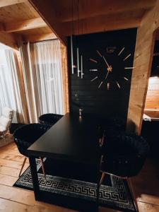 a dining room with a table and a clock on a wall at Parkowy Kudowa in Kudowa-Zdrój