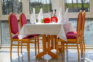 tavolo da pranzo con tovaglia e sedie bianche di AL GONDOLIERE a Oppach