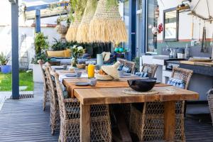 an outdoor dining area with a wooden table and chairs at Biarritz Surf Lodge Chambre d'hôtes in Biarritz