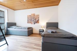 2 camas en una habitación con techos de madera en Work & Stay Apartment Emmerich, en Emmerich