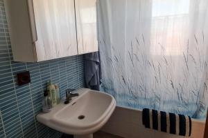a bathroom with a sink and a shower curtain at Ático familiar con todas las comodidades. in Murcia