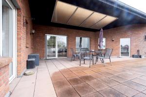 d'une terrasse avec une table, des chaises et un mur en briques. dans l'établissement Work & Stay Apartment Emmerich, à Emmerich