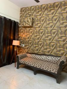 a living room with a couch and a wall at Gorakhnath Guest House in Gorakhpur