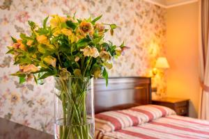 eine Vase mit Blumen auf einem Tisch in einem Schlafzimmer in der Unterkunft Boutique Splendid Hotel in Warna