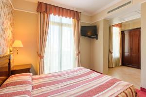 a hotel room with a bed and a window at Boutique Splendid Hotel in Varna City