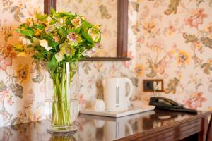 um vaso de flores sentado numa mesa em Boutique Splendid Hotel em Varna