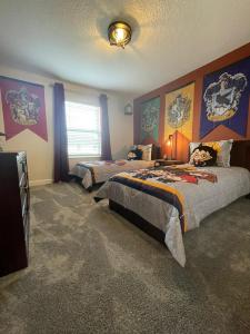 ein Schlafzimmer mit zwei Betten und einem Fernseher darin in der Unterkunft 4321 QS - Magical Haven Townhome w Pool in Kissimmee