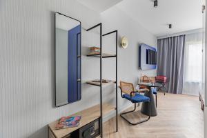 ロワシー・アン・フランスにあるAppart'City Collection Paris Roissy CDG Airportの鏡、テーブル、椅子が備わる客室です。