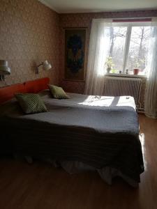 een slaapkamer met 2 bedden en een raam bij Moshults Vandrarhem in Moshultamåla