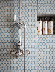 um chuveiro numa casa de banho com quatro garrafas brancas em Artist Residence Bristol em Bristol