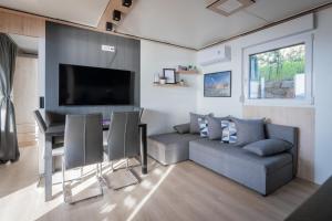 ein Wohnzimmer mit einem Sofa und einem Tisch in der Unterkunft Luxury Mobile home Zuzu Klenovica in Klenovica