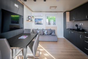 eine Küche und ein Wohnzimmer mit einem Tisch und einem Sofa in der Unterkunft Luxury Mobile home Zuzu Klenovica in Klenovica