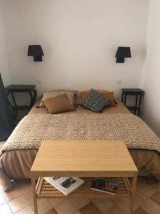 1 dormitorio con 1 cama con mesa de madera en La grande et petite porte de Samois, en Moret-sur-Loing