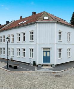 un gran edificio blanco con techo rojo en Sentral og fargerik bygårdsleilighet en Halden