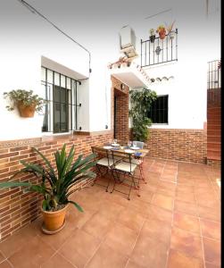 patio con tavolo e muro di mattoni di Casa los Geranios ad Arcos de la Frontera