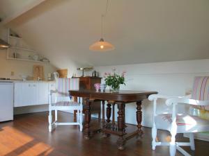 ベルゲンにあるCozy Cottage in Bergen with Terraceのキッチン(木製テーブル、椅子付)、ダイニングルーム