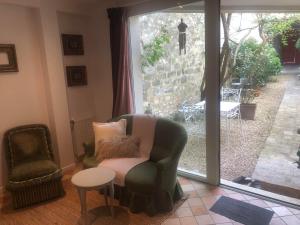 sala de estar con silla, mesa y ventana en La grande et petite porte de Samois, en Moret-sur-Loing