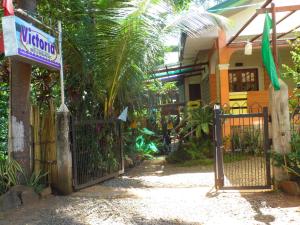 Una puerta a una casa con un cartel. en Victoria Guest House and Cottages, en Puerto Princesa City