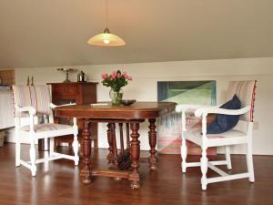 ベルゲンにあるCozy Cottage in Bergen with Terraceのダイニングルームテーブル(椅子2脚付)、花瓶