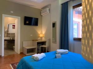 維博瓦倫蒂亞的住宿－Villa Zufrò，一间卧室配有一张蓝色的床、一张桌子和一个窗户。